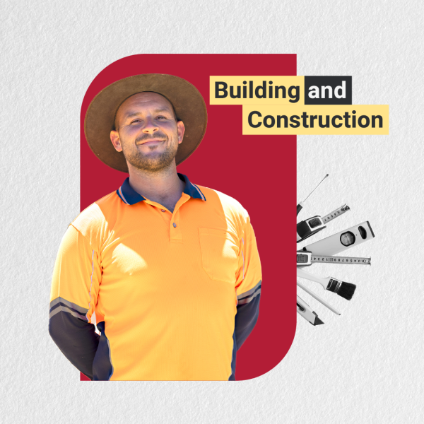 A man wearing a hat and orange shirt stands in front of a building with a construction logo displayed prominently.